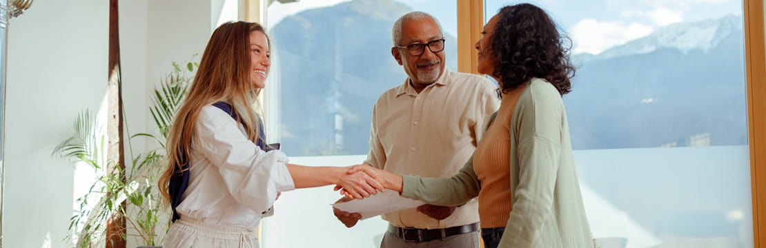 A financial professional meeting with two investors to discuss social enterprise investments that align financial goals with meaningful causes.