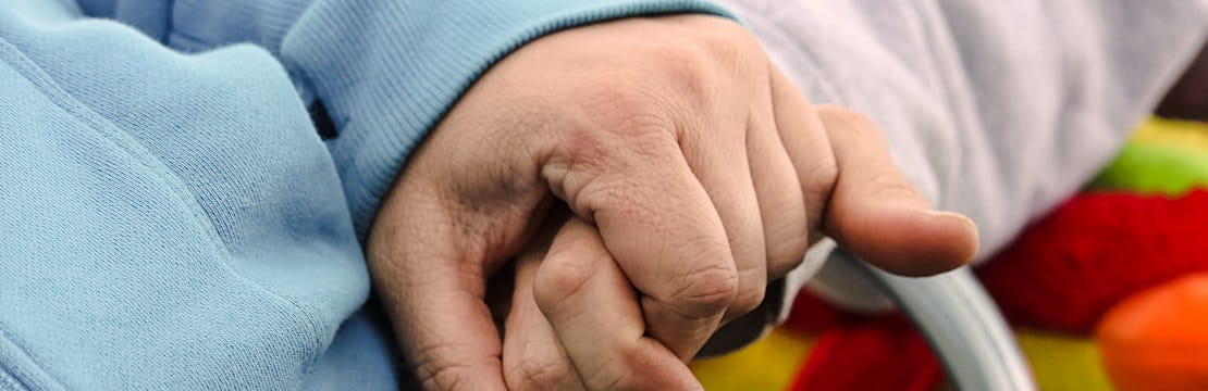 Pair of hands holds each other.